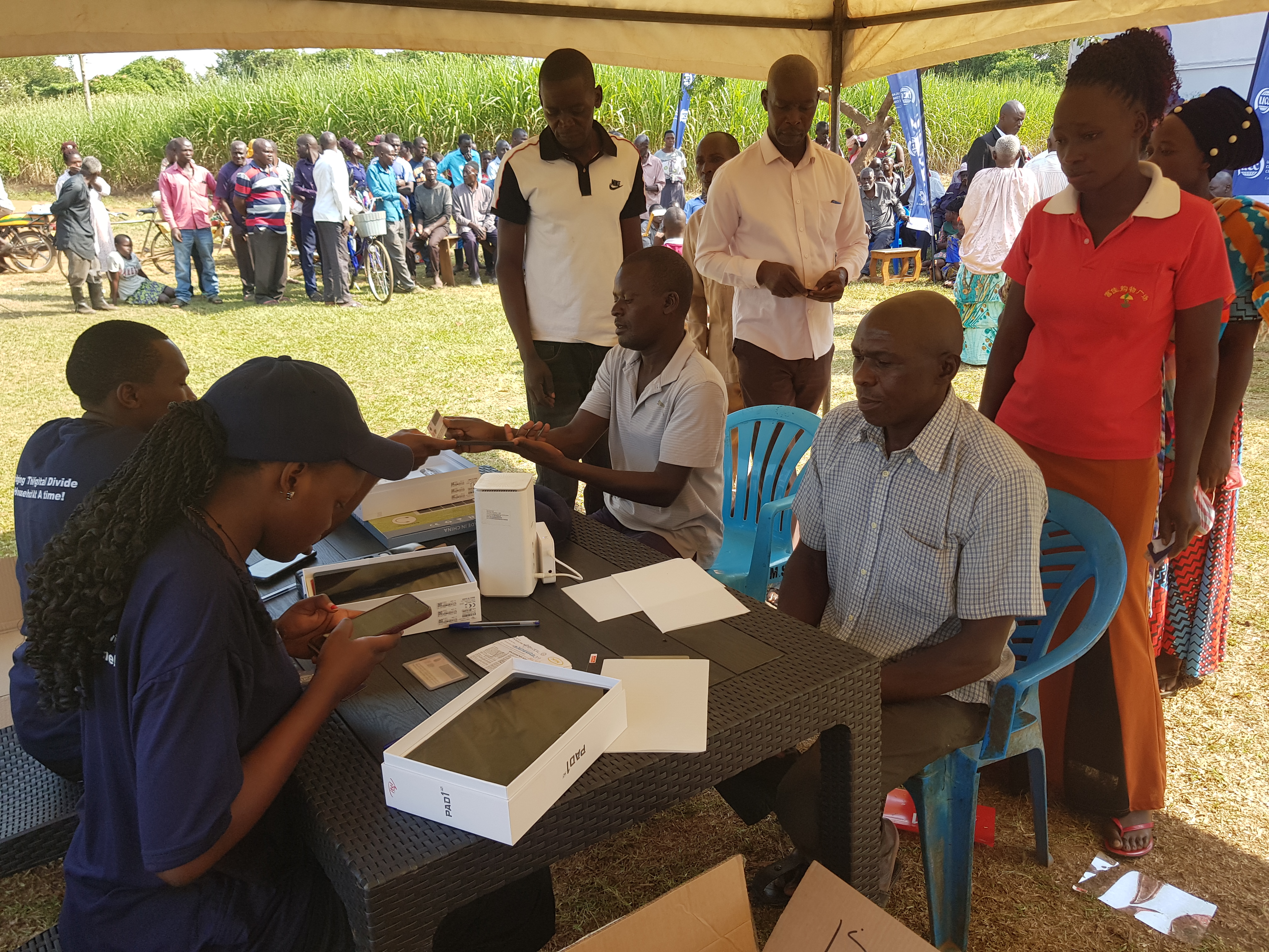 Uganda Communications Commission distributing tablets to beneficiaries in Namwendwa TC in a pilot project